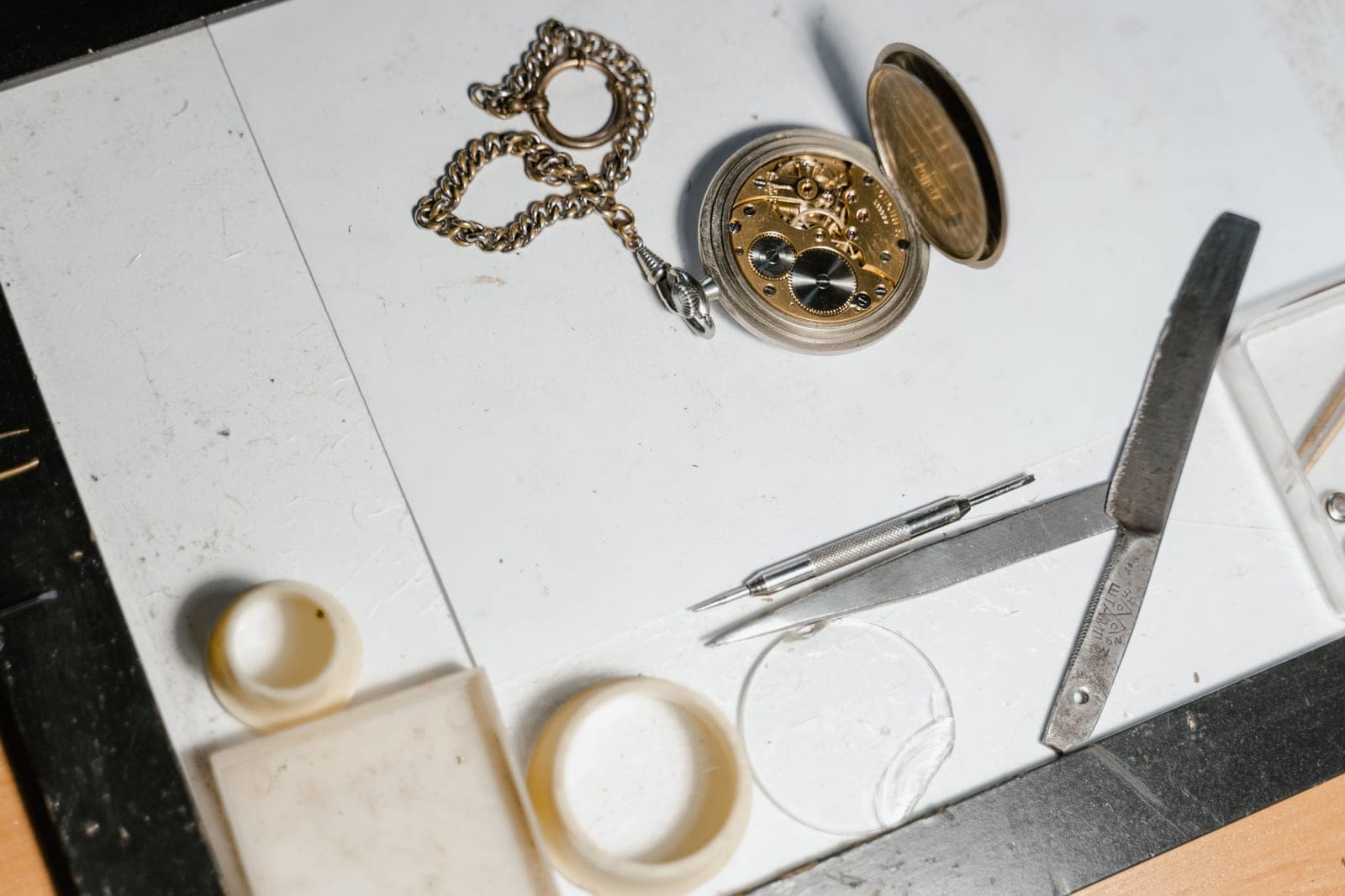 Hands assembling a watch at a small workbench